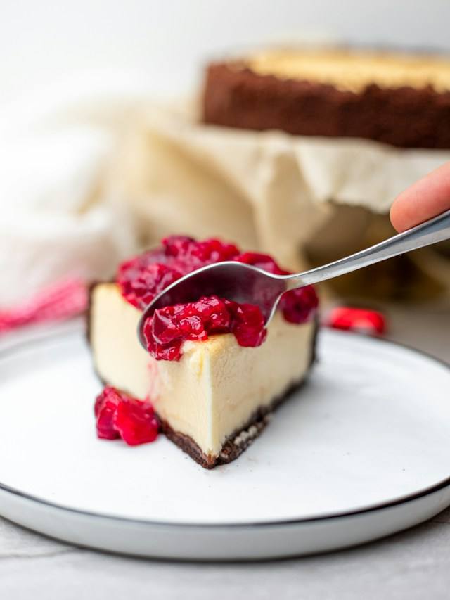 Kousek pečeného cheesecaku s višňovou omáčkou