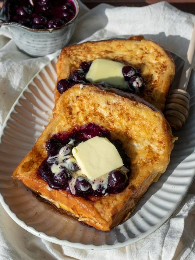 Francouzské toasty s kardamomem Francouzské toasty s borůvkami a máslem na talíři